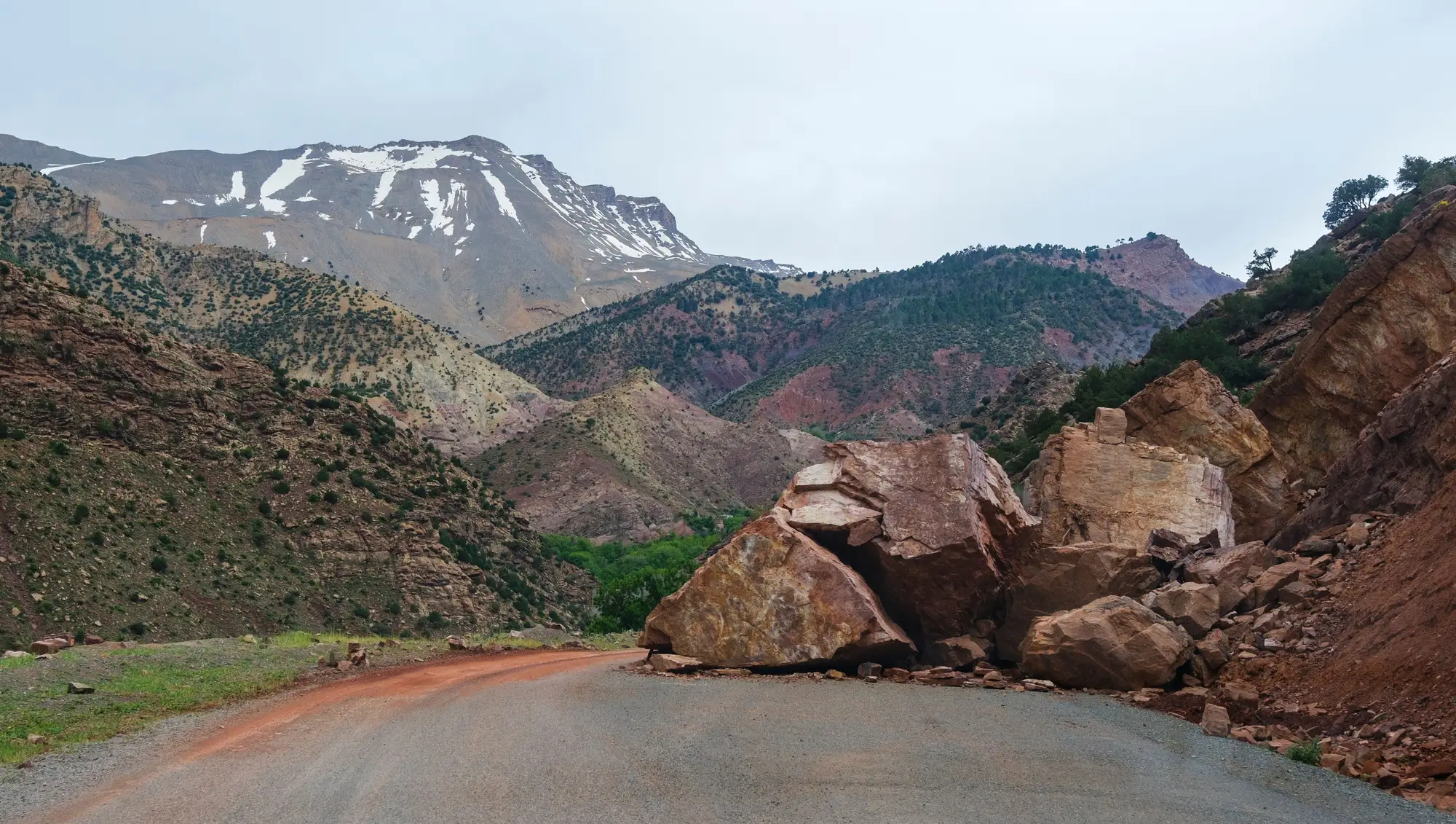 Boulders from a rockfall lying across a mountain road