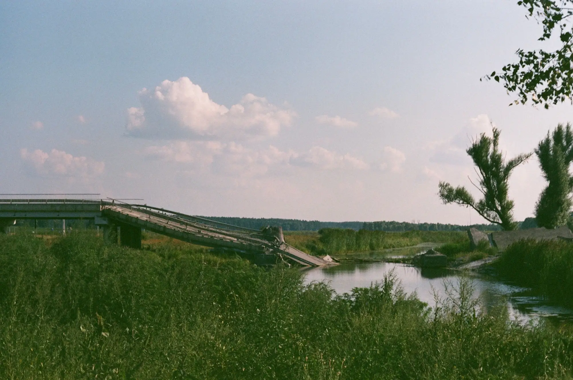 A road bridge with its deck dropped into the river, the approach still standing